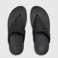 A pair of black Fit Flop Lulu Shimmerglitz comfort sandals, presented in a flat-lay view on a white background.