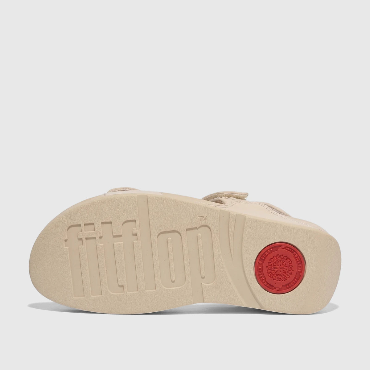Bottom view of a light tan Fit Flop Lulu Adjustable Leather Comfort Sandal, showcasing the embossed Fitflop logo on the sole.