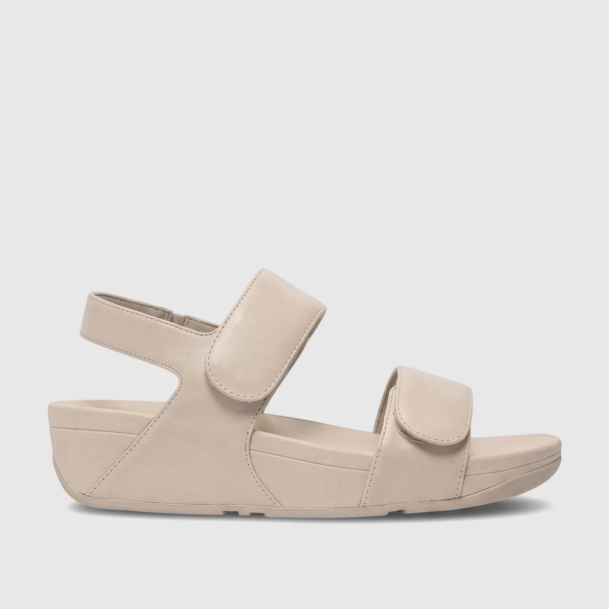 Light tan Fit Flop Lulu adjustable leather comfort sandals with a back strap, shown in a side profile view on a light