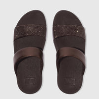Pair of chocolate brown Fit Flop Lulu Crystal Embellished Slide sandals, featuring one plain and one crystal-studded strap,