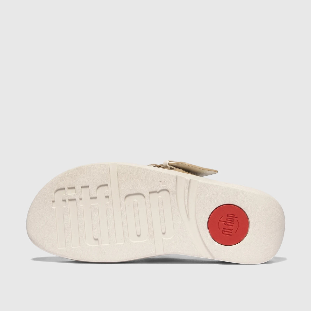 Underside view of a Fit Flop Lulu Resin Buckle Leather Cross Slide sandal with an off-white sole and red logo.