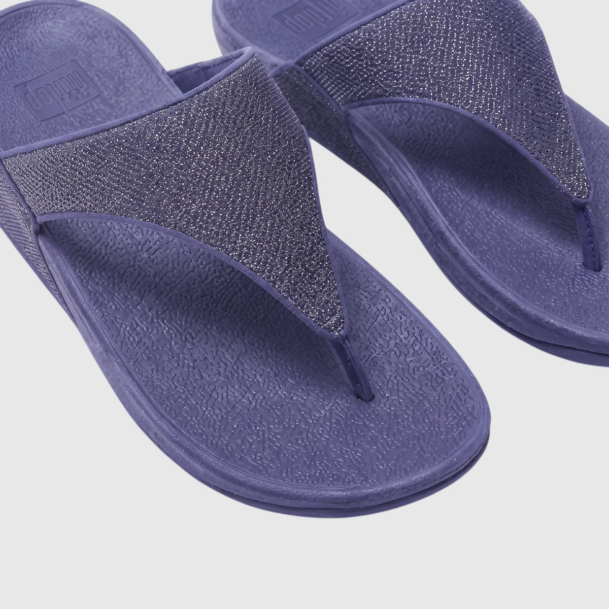 Close-up of a pair of Fit Flop Lulu Shimmerglitz Nightfall Blue comfort sandals with textured straps and a platform sole.