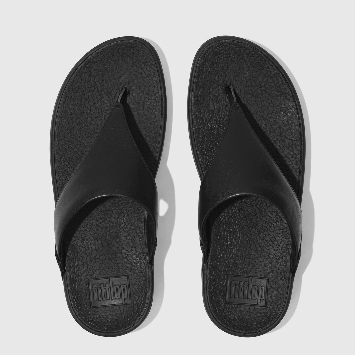 Black FitFlop Lulu leather comfort sandals, viewed from directly above, featuring thick thong straps and contoured footbeds.