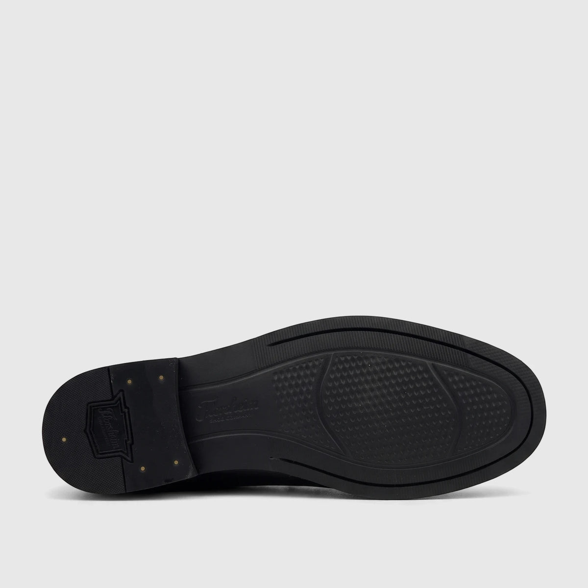 Close-up of the black sole of a Florsheim Men's Berkley Flex Venetian slip-on shoe, featuring textured grip and brand logos.