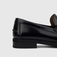 Side view of a Florsheim Men's Slip On Berkley Flex Venetian loafer in black, showcasing the shiny leather finish and heel.