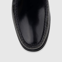 Close-up top-down view of a black Florsheim Men's Berkley Flex Venetian slip-on loafer shoe made of shiny leather.