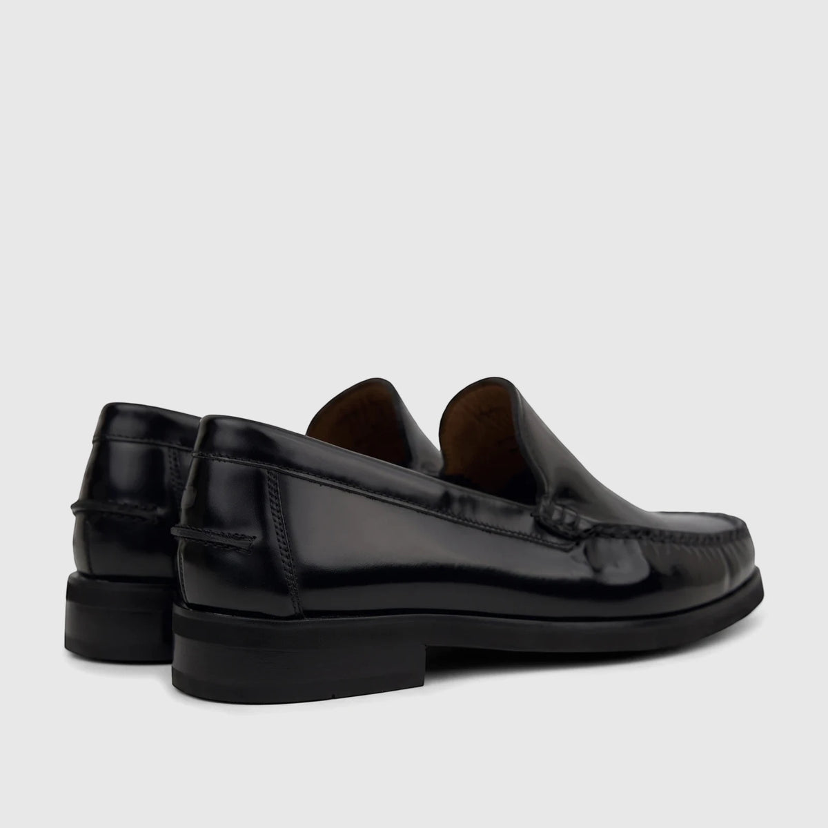 Black shiny leather men's slip-on loafers from Florsheim, showing the rear and side view on a white background.
