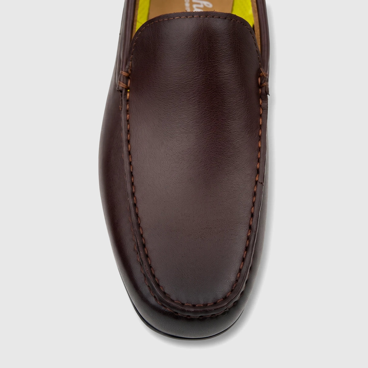 Close-up top-down view of a dark brown Florsheim men's leather loafer with visible stitching and yellow interior lining.
