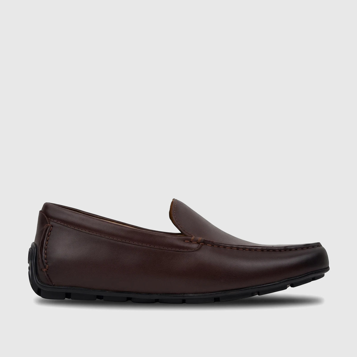 Dark brown Florsheim Men's Loafer Motor Moc shoe, made of leather with moc toe stitching, captured in a side view.