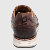 Back view of a Florsheim Men's Launch Elastic Lace Slip On shoe in dark brown leather with a light sole.