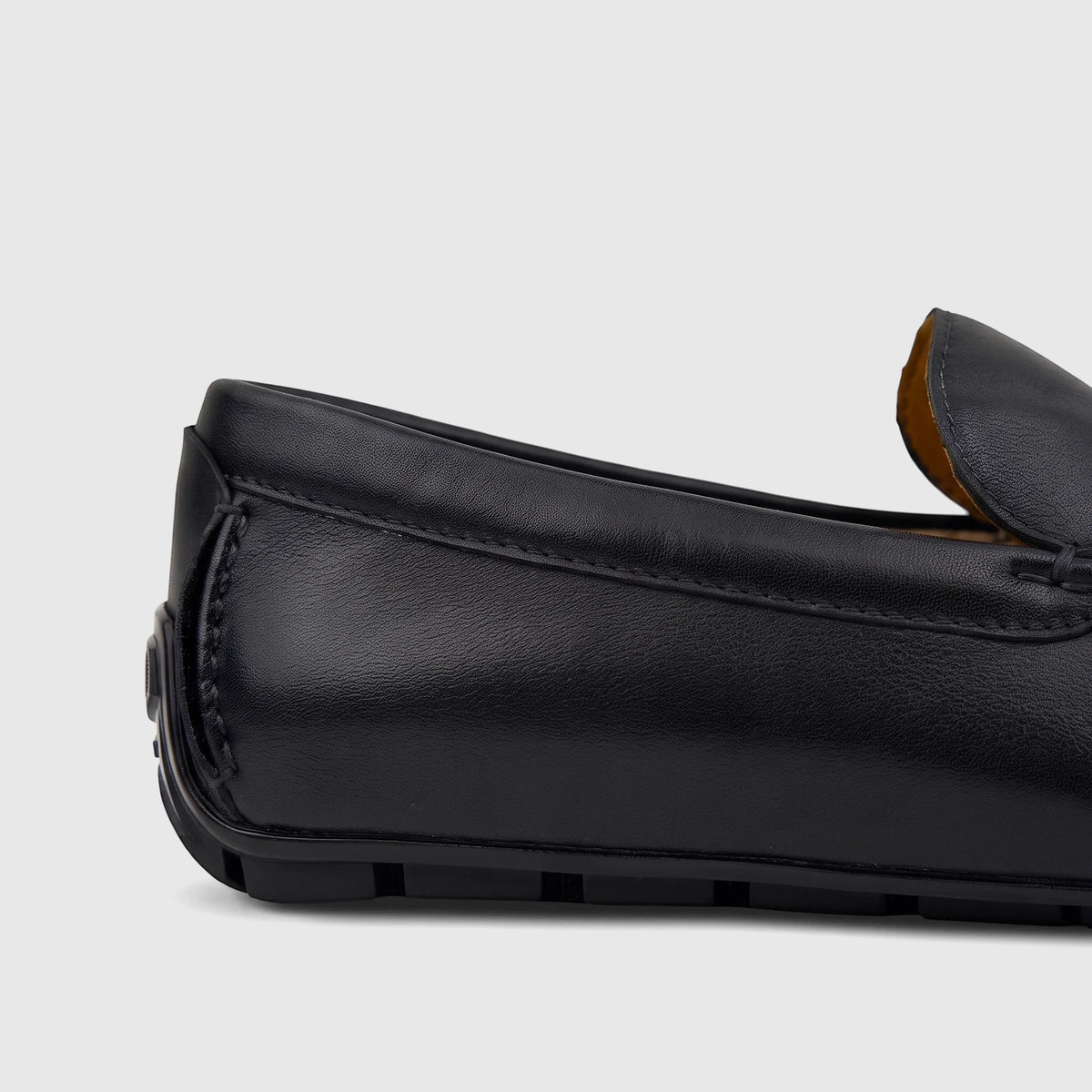 Close-up of a black leather men's Florsheim Motor Moc loafer, showcasing the textured leather and stitched details from the