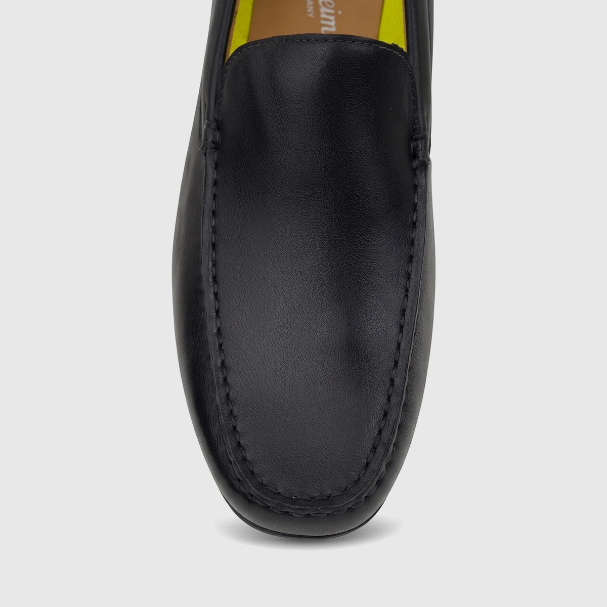Close-up front view of a Florsheim Men's Motor Moc loafer in black leather with mocc-toe stitching.