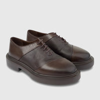 Pair of brown formal leather lace-up oxford shoes with chunky soles, featuring smooth and pebbled textures.