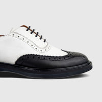 Close-up of a Formales ladies' black and white leather full brogue wingtip lace-up shoe with detailed perforations.
