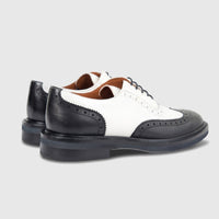 A pair of Formales Ladies Leather Full Brogue Wingtip Lace Up shoes in black and white, featuring intricate perforations and