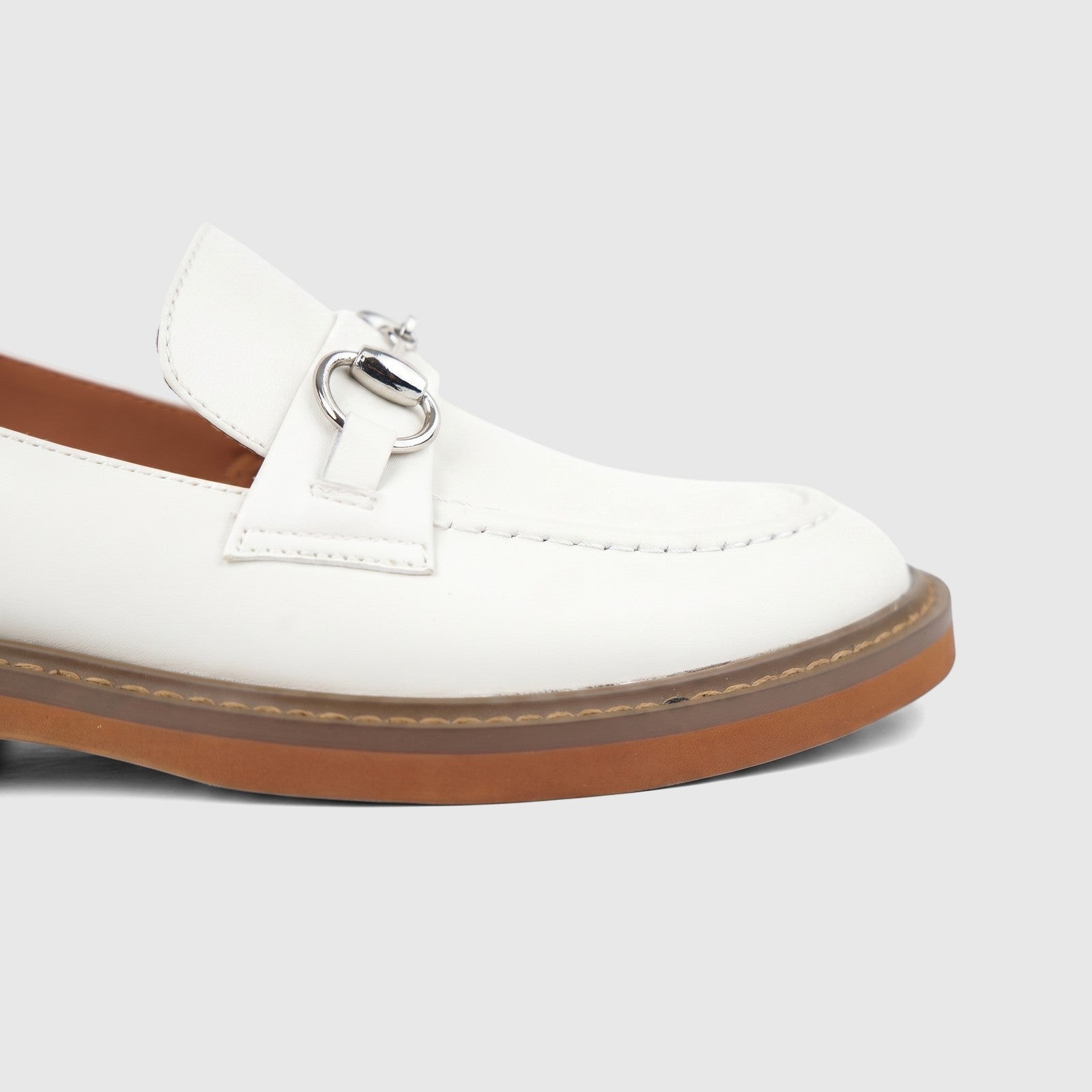 Close-up of a Formales Ladies Leather Loafer in off-white, featuring a classic design with silver-tone bit buckle hardware