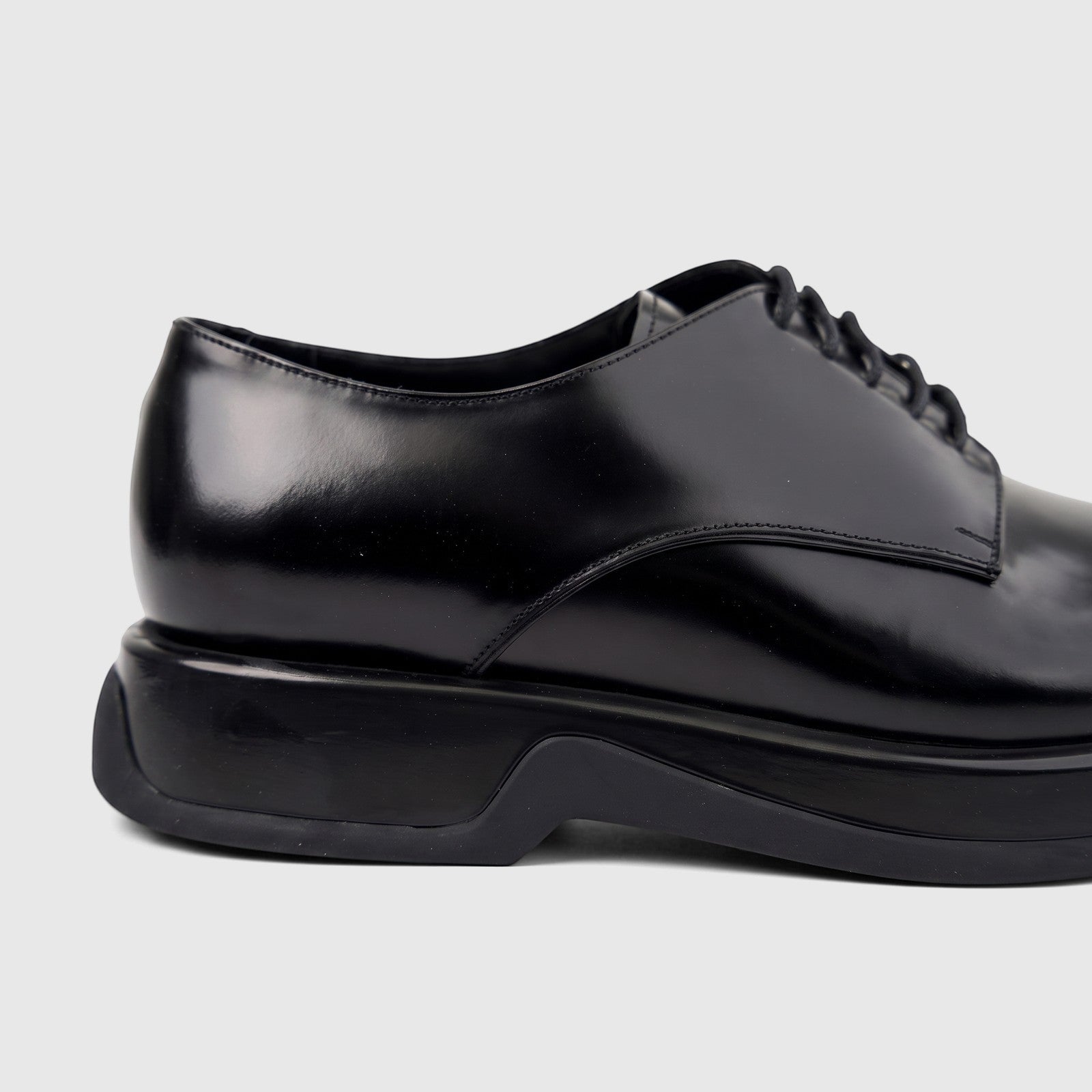Close-up of Formales Men's black high-shine leather chunky sole lace-up shoe from the side.