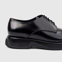 Close-up of Formales Men's black high-shine leather chunky sole lace-up shoe from the side.