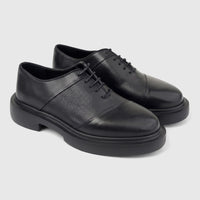 A pair of black leather Formales men's lace-up shoes with chunky soles, viewed from the side on a white background.