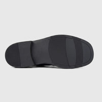 Underside view of a Formales men's black leather slip-on shoe, featuring a chunky sole with textured patterns and branding.