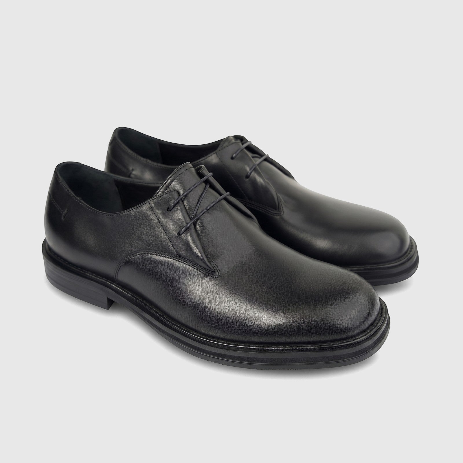 A pair of black leather men's formal laced shoes featuring chunky soles, photographed from a high angle.