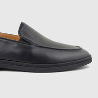 Close-up of a Formales Men's Black Leather Loafer, showcasing the textured upper and ribbed vamp details.