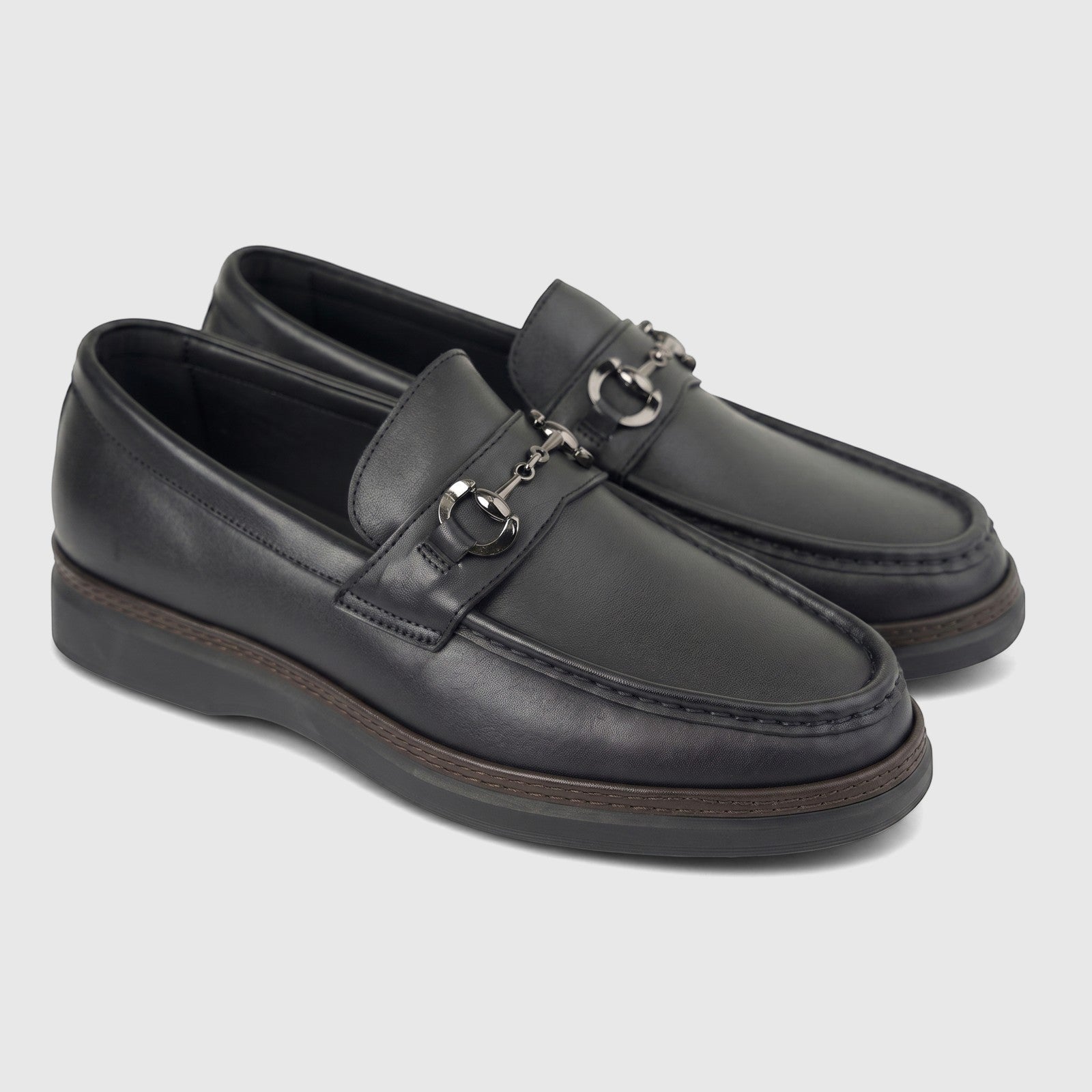 A pair of men's black leather loafers, featuring gunmetal horsebit hardware on the vamp and a visible brown sole trim,