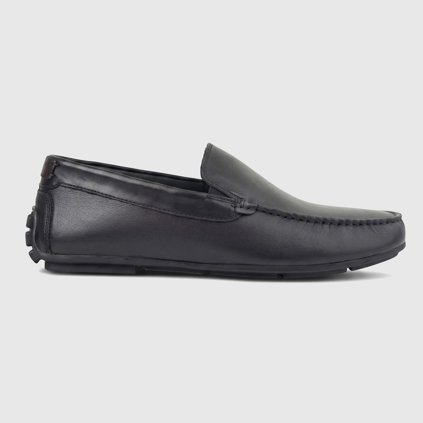 Formales Men's black leather loafer, side view, featuring moc-toe stitching and a detailed rubber sole.