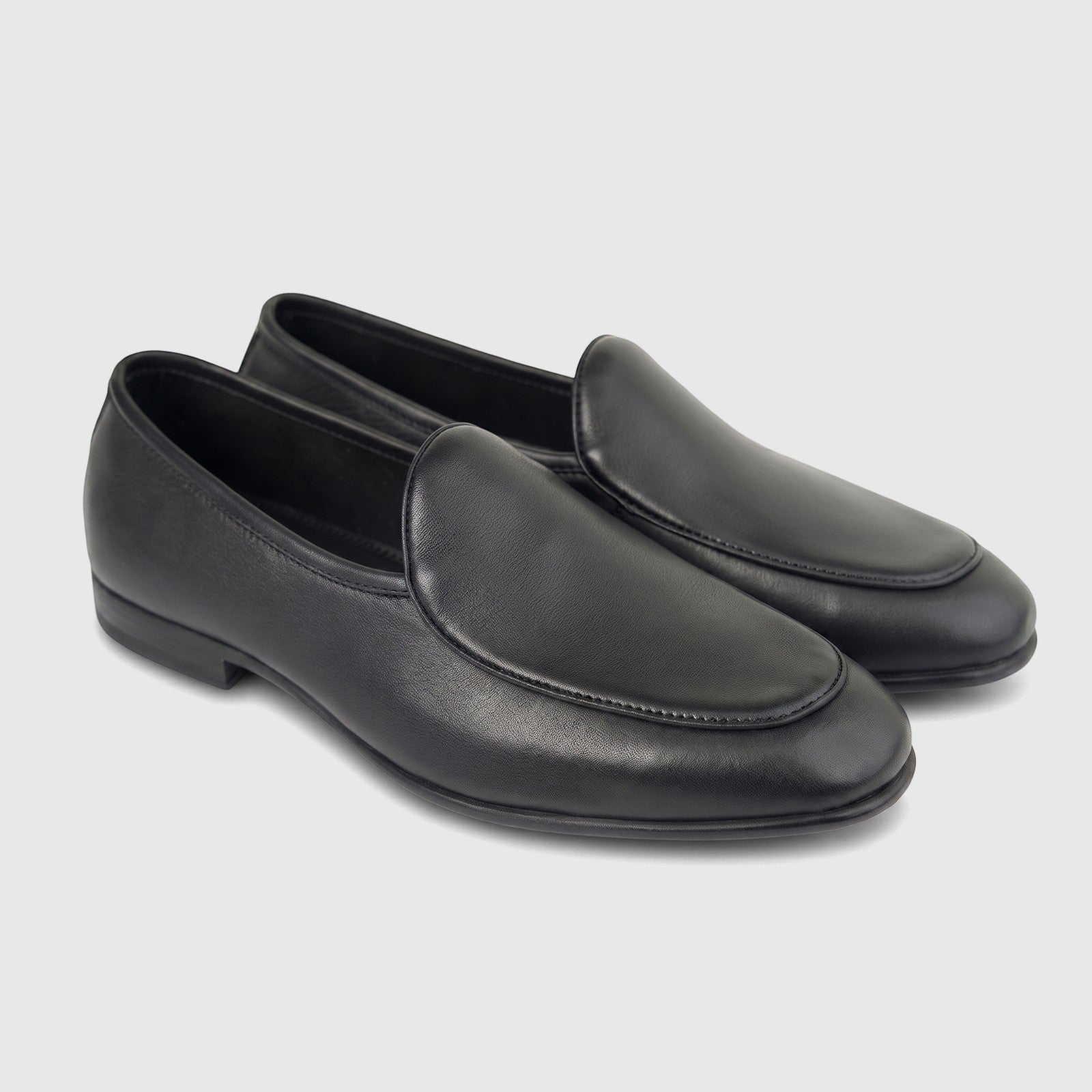 A pair of men's black leather loafers, featuring a sleek design with detailed stitching, presented on a white background.