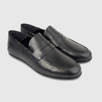 A pair of elegant black leather men's slip-on loafers, seen from a slightly elevated front-side angle on a white background.