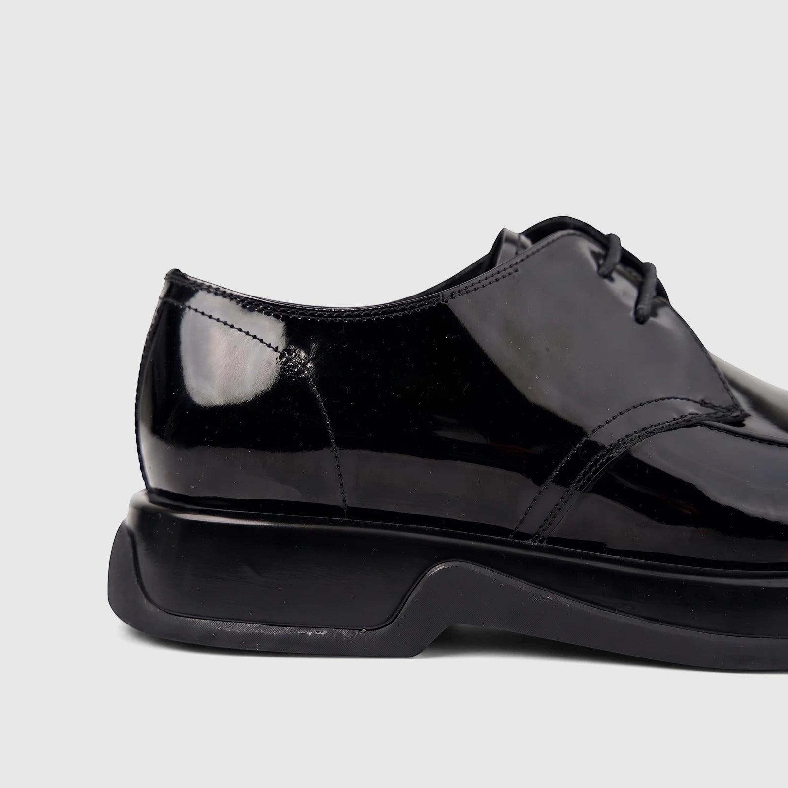 Side view of a Formales men's black patent leather lace-up shoe with a chunky sole, offering a sleek and polished look.