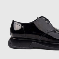 Side view of a Formales men's black patent leather lace-up shoe with a chunky sole, offering a sleek and polished look.