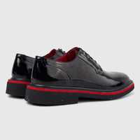 Pair of Formales men's black patent leather lace-up shoes with chunky ridged soles and red trim, shown from a rear-side view.