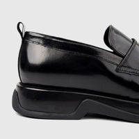 Close-up side view of a Formales Men's black patent leather loafer with a chunky sole.