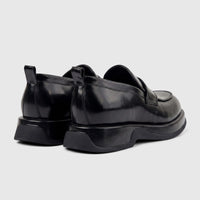 Black patent leather chunky sole loafers for men, featuring pull tabs at the heel, shown from a rear-side view.
