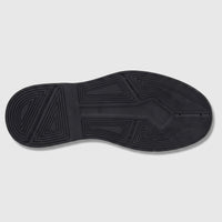 Bottom view of Formales Men's black patent leather shoe, showcasing the chunky rubber sole with geometric tread pattern and