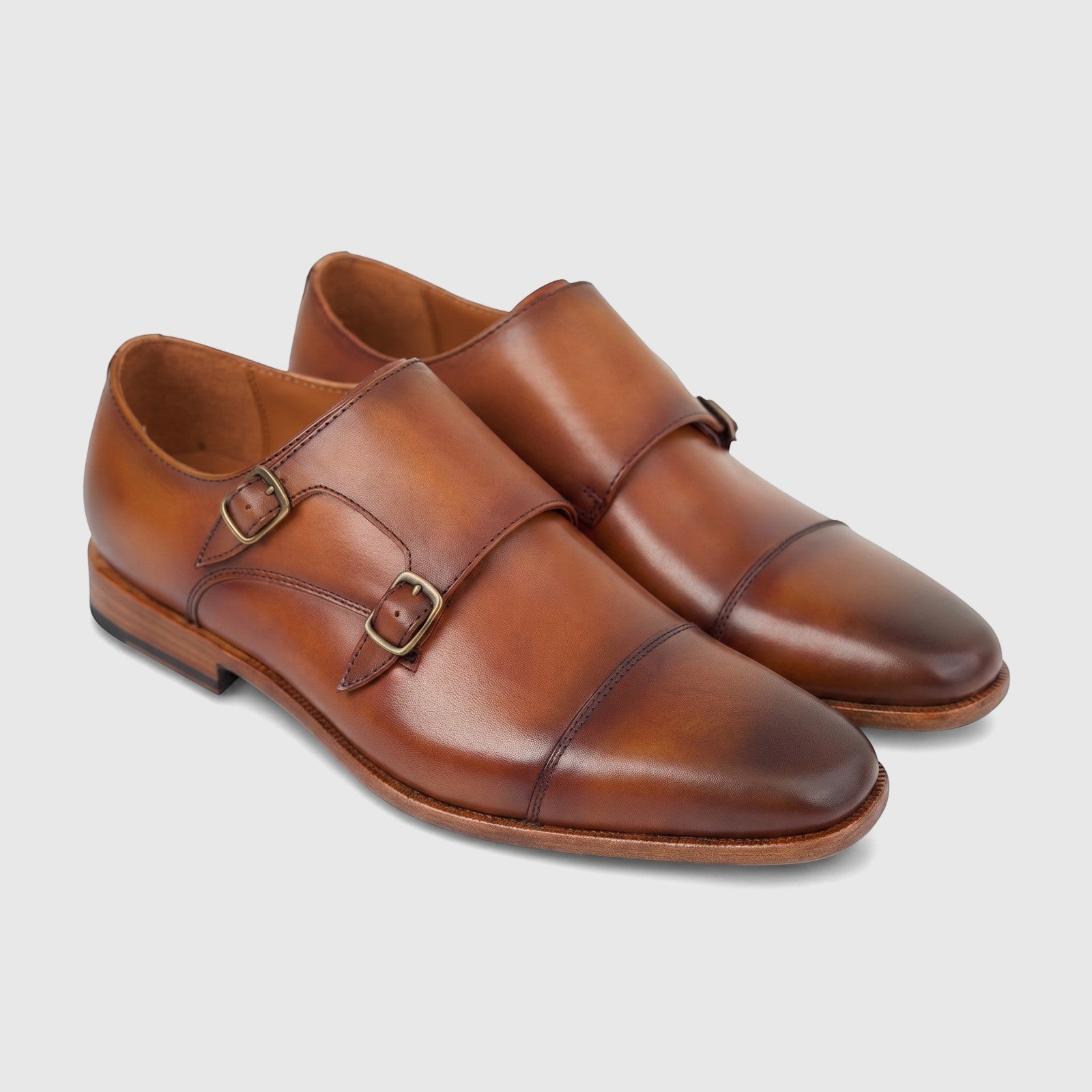 A pair of Formales men's brown leather double monk strap dress slip-on shoes with burnished toes and brass buckles, captured