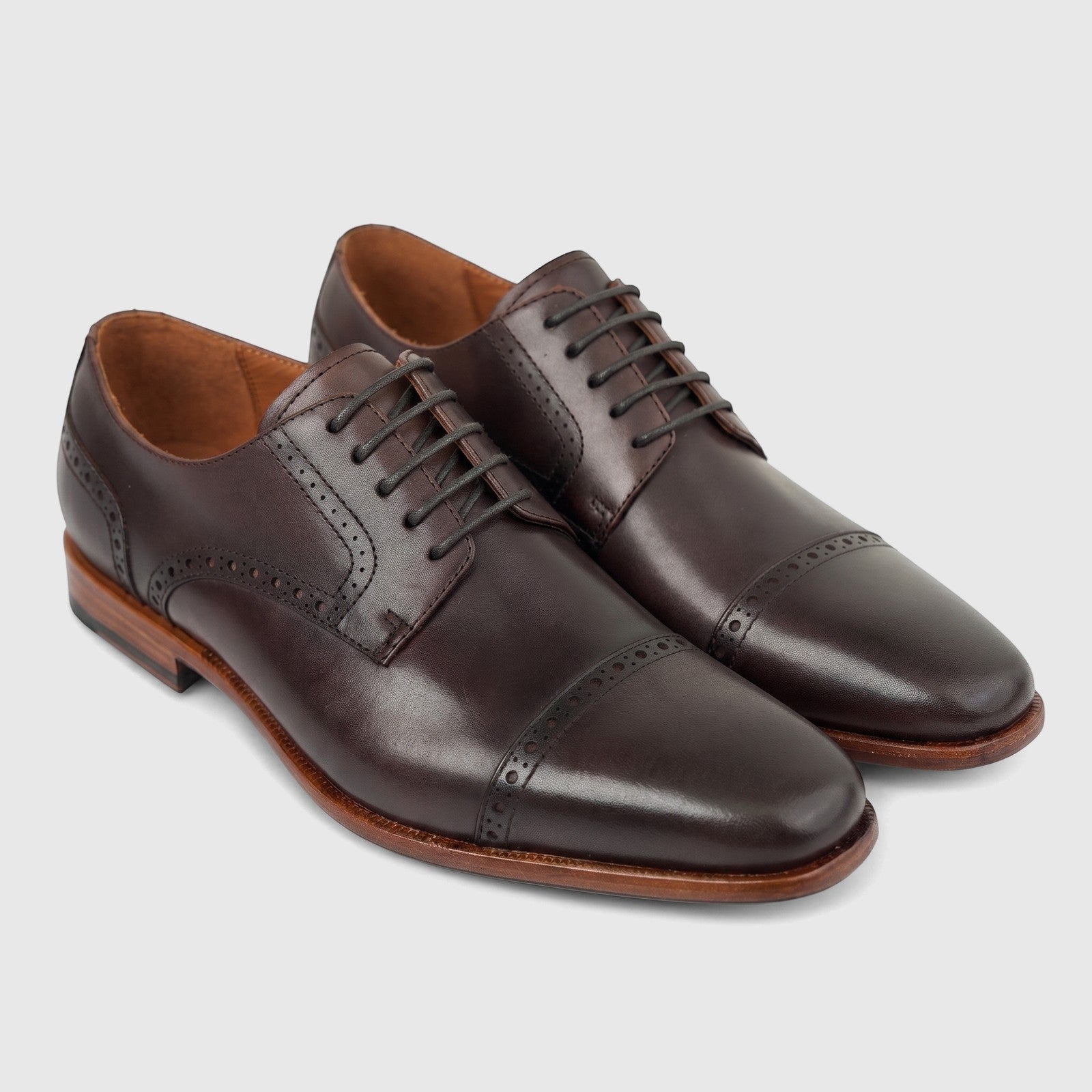 Pair of Formales men's coffee brown leather lace-up dress shoes with cap toe and brogue detailing, side view.