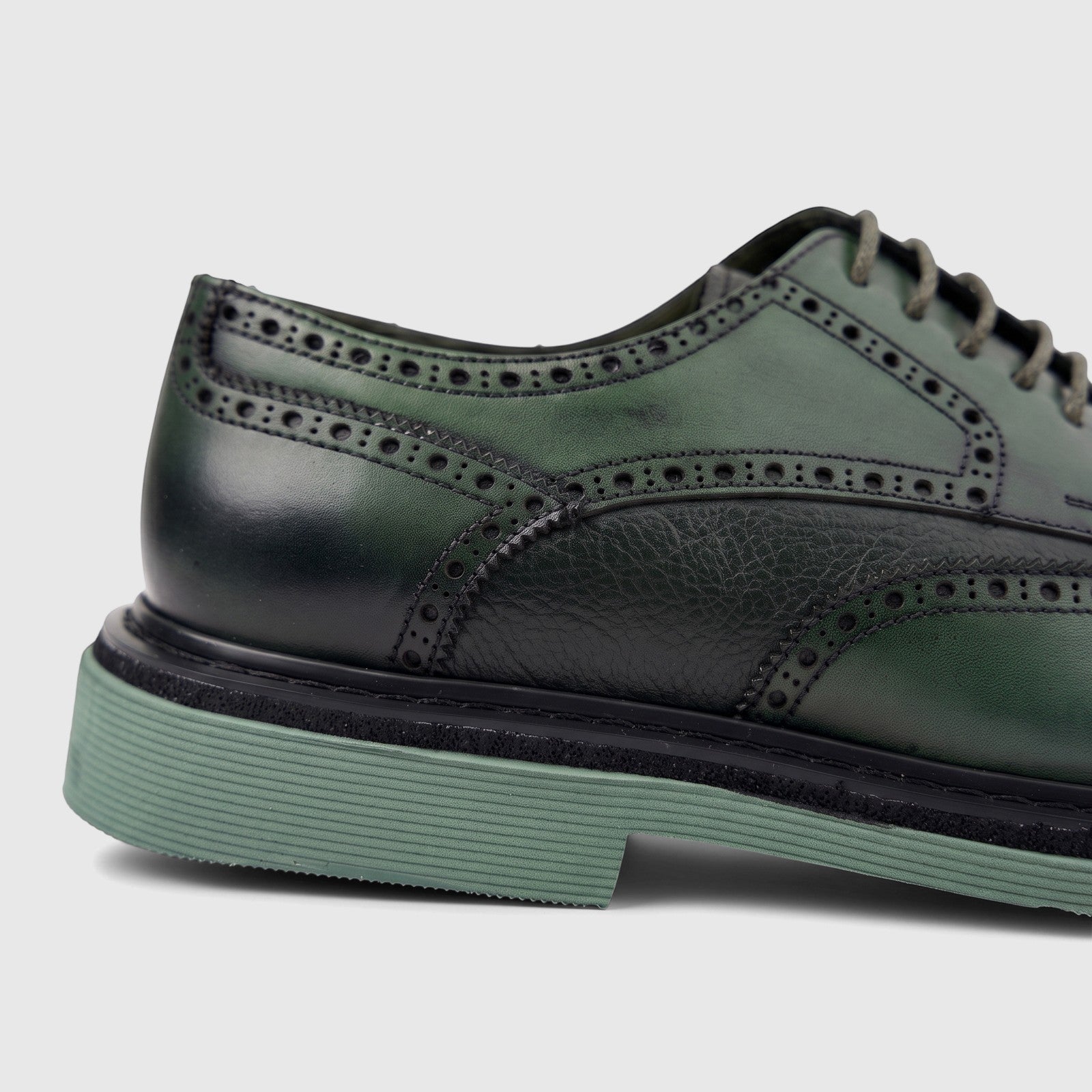 Close-up of a Formales men's olive green leather brogue lace-up shoe with a chunky green sole, showcasing detailed