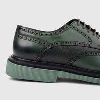 Close-up of a Formales men's olive green leather brogue lace-up shoe with a chunky green sole, showcasing detailed