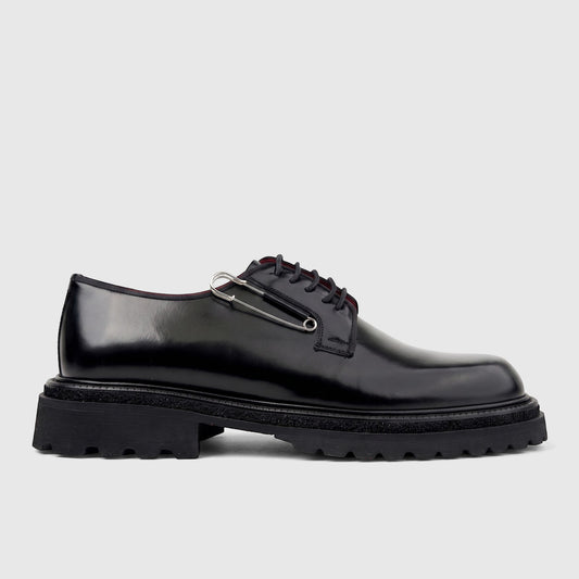 Formale's Men's black leather lace-up shoe with a chunky lug sole and a silver safety pin detail, shown in a side profile