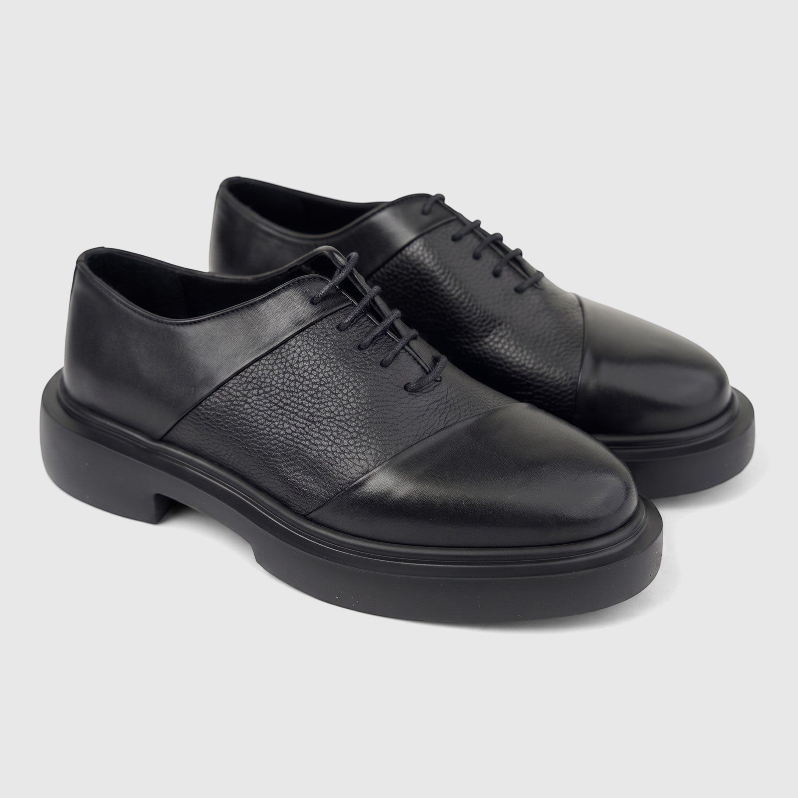 A pair of black leather Formales men's lace-up shoes with chunky soles, viewed from the side on a white background.