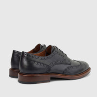 Pair of black leather men's Formales chunky sole lace-up brogue shoes, seen from a rear-side view on a white background.