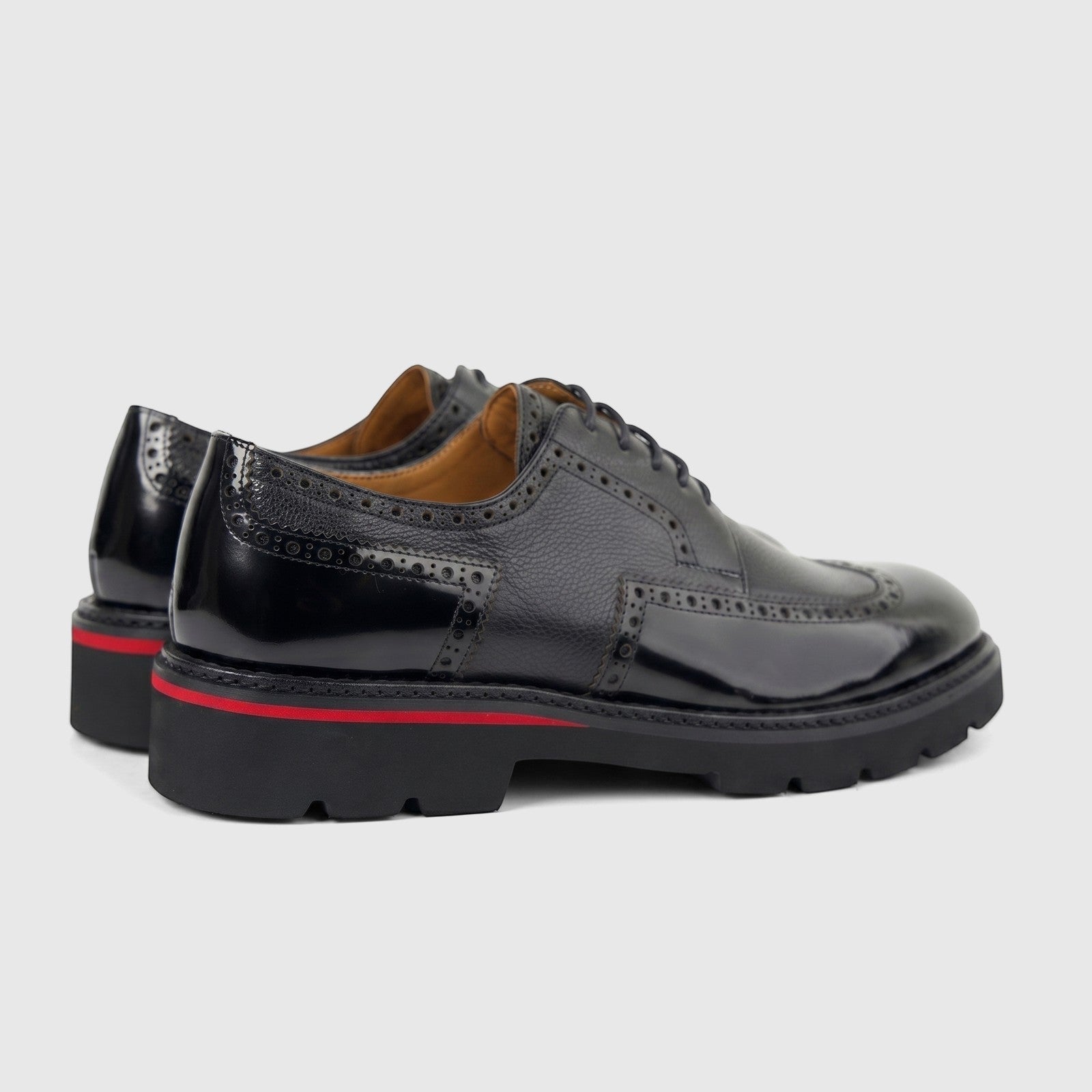 Pair of Formales men's black leather chunky sole lace-up shoes with brogue details and a red stripe, viewed from the