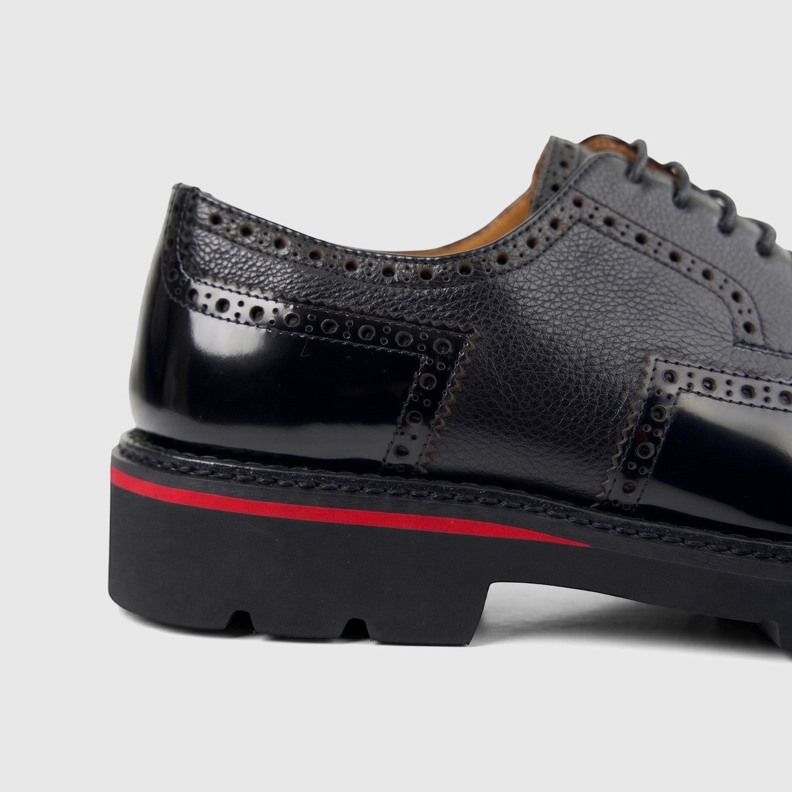 Close-up of a Formales men's black leather lace-up shoe with chunky sole and brogue detailing.