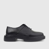 Black leather men's chunky sole lace-up shoe, shown from the side, highlighting its smooth and pebbled textures.