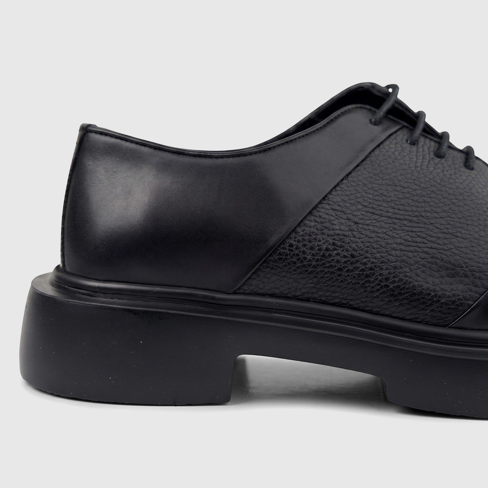 Black leather men's formal lace-up shoe with a chunky sole, shown from the side view on a white background.