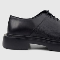 Black leather men's formal lace-up shoe with a chunky sole, shown from the side view on a white background.