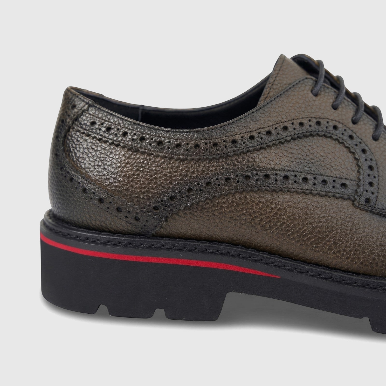 Khaki men's leather lace-up formal shoe with a chunky black sole and red stripe, shown in a close-up side view.
