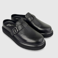 A pair of black Formales men's leather chunky sole mules with silver buckle details, viewed from the side on a white